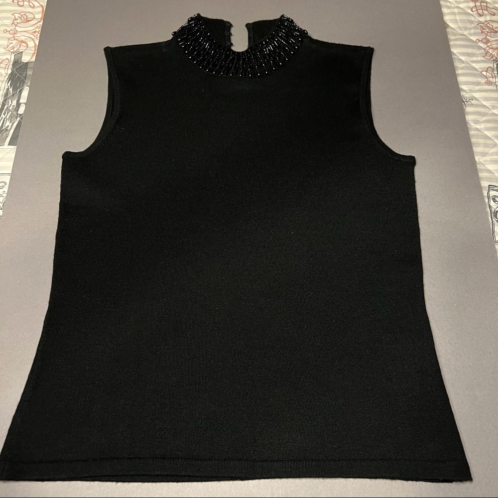Black sleeveless top with embellished neckline. Size petite.